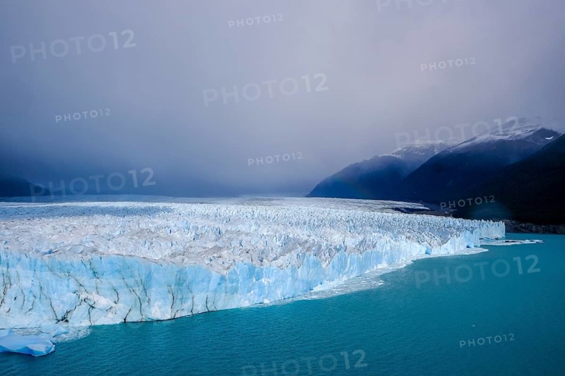 El Calafate, Patagonia, Argentina, Perito Moreno Glacier in Los Glaciares National Park. The Perito Moreno Glacier is part of the Patagonian ice field, the Campo Hielo Sur, the third largest freshwater reserve in the world. It is located in the province of Santa Cruz on Lago Argentino, the country's largest lake. The Perito Moreno Glacier is up to 30 kilometres long and 5 kilometres wide. Its edge is 70 metres high at its highest point. Small icebergs that have broken off from the glacier float in Lago Argentino. The glacier is one of the most beautiful sights in South America and is one of the most visited attractions in Argentina, South America