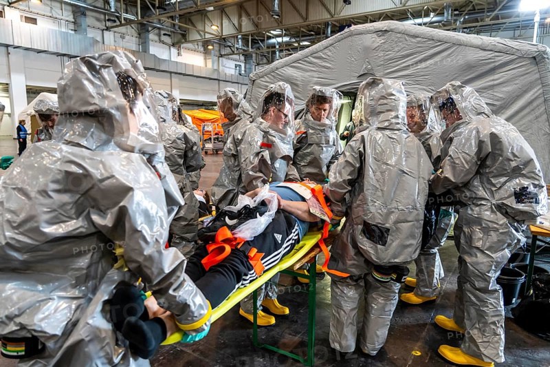 Decontamination of injured persons after an assumed accident involving hazardous substances, fire brigade and aid organisations practise setting up and operating a decontamination station, injured persons are sighted and then washed in a special shower tent to remove possible hazardous substances and chemicals in order to avoid further injuries, the emergency services wear special, ventilated protective suits, large-scale exercise by the Essen fire brigade
