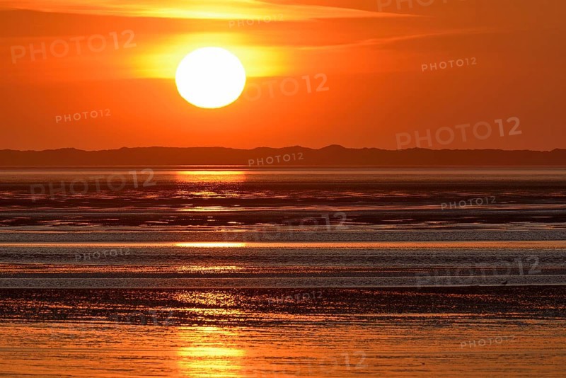 Sunset over the North Sea at low tide, the outline of the island of Juist on the horizon, Norddeich, Lower Saxony, Germany, Europe