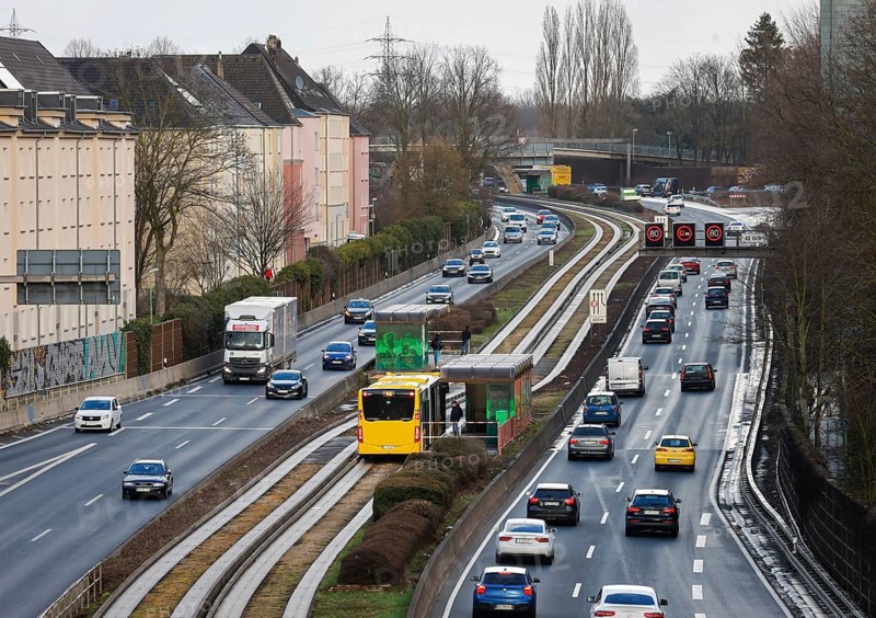 Essen, North Rhine-Westphalia, Germany - Cars and a public bus drive through Essen city centre on the A40 motorway