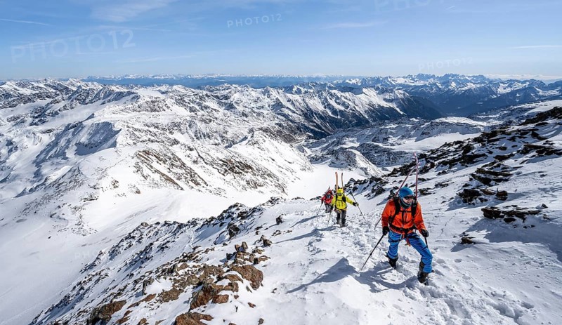 Ski tourer on foot, carrying skis on backpack, mountain panorama, snow-covered mountain landscape in winter, high tour, ascent to Monte Cevedale, Ortler Alps, Vinschgau Valley, Italy, Europe