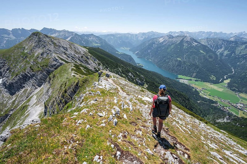 Mountaineer on the summit ridge of the Unnütz, behind Achensee and summit of the Seekarspitze Unnütz crossing, Brandenberg Alps, Tyrol, Austria, Europe