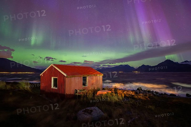 Northern Lights over a hut at the Lyngenfjord, Lyngen Alps, Lyngen, Troms og Finnmark, Norway, Europe