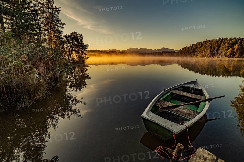 Boats in the autumnal Schmutter Weiher in the Allgäu near the municipalities of Halblech, Roßhaupten and Lechbruck in Ostallgäu in the foothills of the Alps