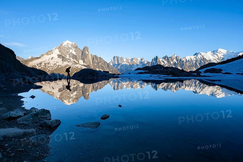 Mountaineer, silhouette in front of mountain landscape in the evening light, water reflection in Lac Blanc, mountain peak, Aiguille Verte, Grandes Jorasses, Aiguille du Moine, Mont Blanc, Mont Blanc massif, Chamonix-Mont-Blanc, Haute-Savoie, France, Europe
