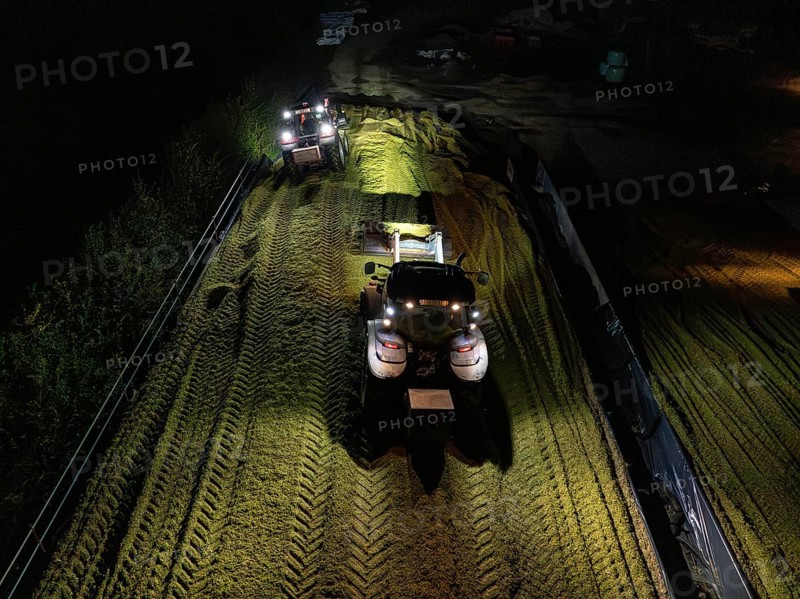Two tractors filling and levelling a silo at night, maize harvest, Dachtel, Black Forest, Germany, Europe