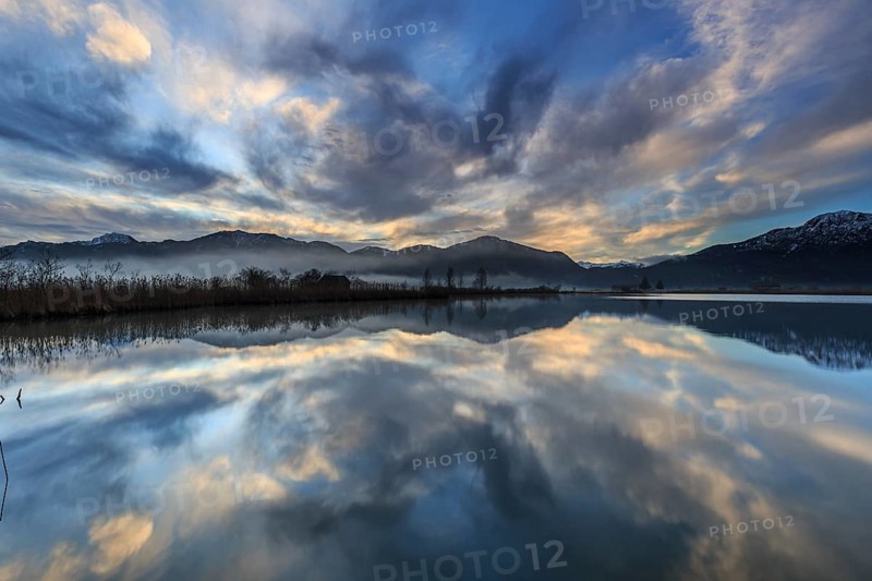 Mountains reflected in a lake at sunrise, cloudy mood, winter, Loisach-Lake Kochel moor, Alpine foothills, Bavaria, Germany, Europe