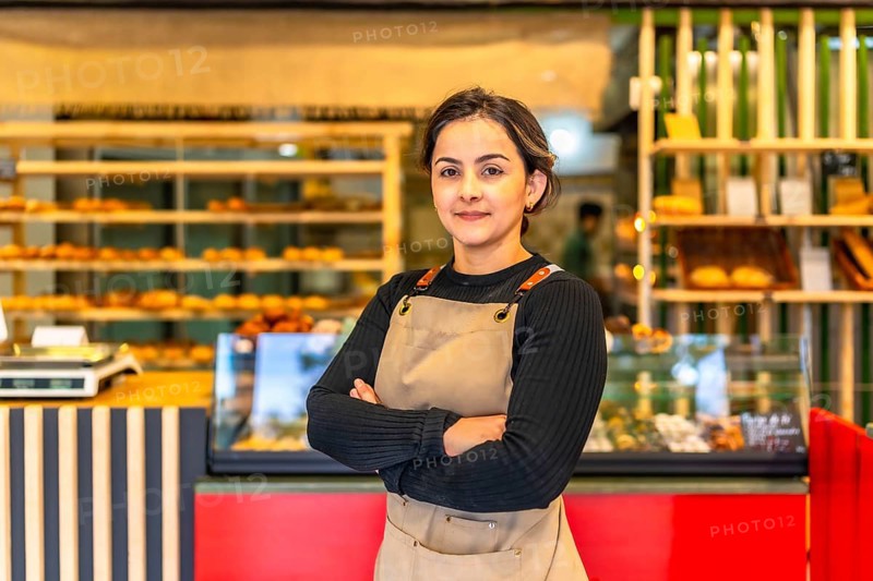 Portrait of a proud female latin owner of an artisan bakery standing with arms crossed in the shop