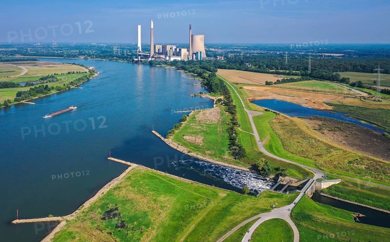 Dinslaken, North Rhine-Westphalia, Germany - Emscher estuary into the Rhine. On the right, the construction site of the new Emscher estuary in front of the decommissioned STEAG coal-fired power plant in Voerde. The mouth of the Emscher into the Rhine is being moved almost 500 metres north from Dinslaken to Voerde. Fish will then be able to swim barrier-free up the new Emscher from the Rhine through a newly created floodplain area. Following the construction of a parallel sewer, the Emscher has been completely free of sewage since January 2022. The river was previously an open, above-ground combined sewer with rainwater and wastewater