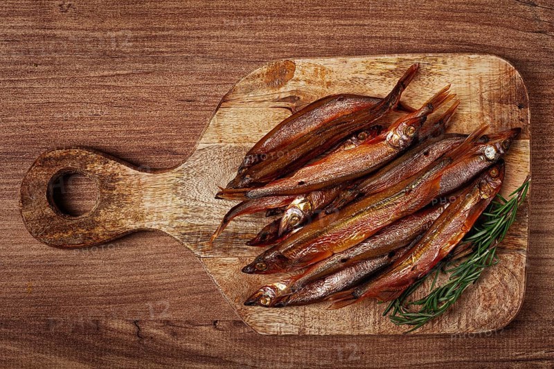 Cold smoked capelin, on a wooden chopping board, no people