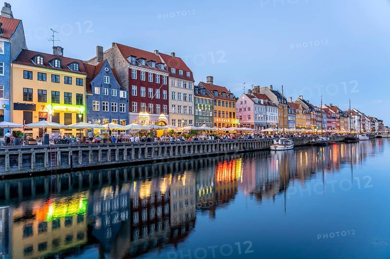 Colourful houses, restaurants and historic ships on the Nyhavn canal and harbour at dusk, Copenhagen, Denmark, Europe