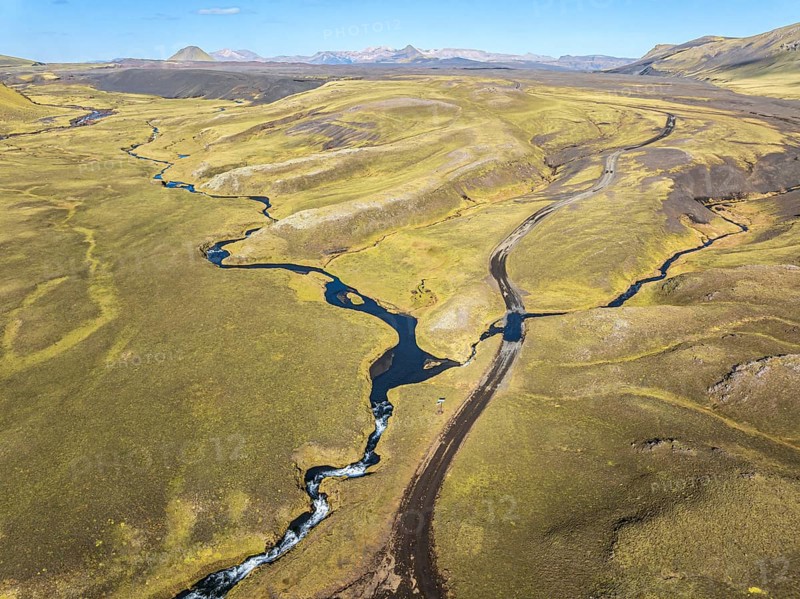 Road F232 Öldufellsleid, ford at waterfall of river bláfjallakvísl, along northern slopes of moss-covered Mt. Öldufell, Mt. Maelifell in the back, black lava sand, Iceland, Europe