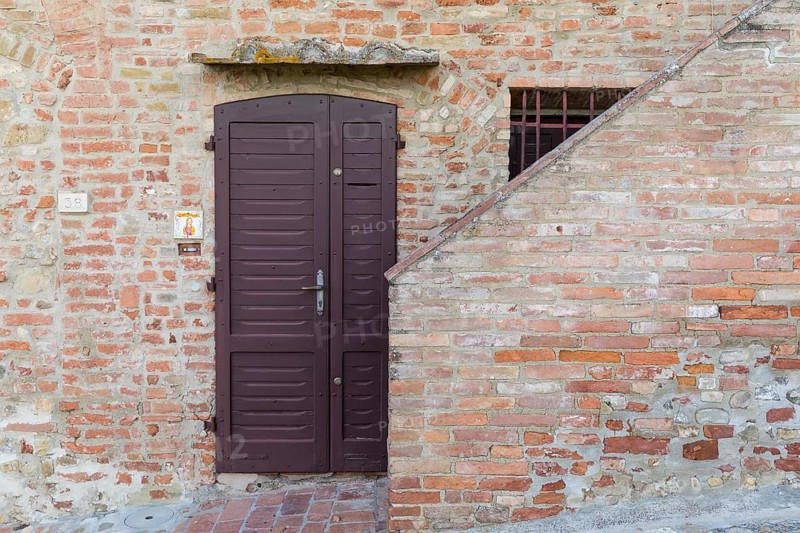 Front door on a house wall, old town centre of Certaldo, Tuscany, Italy, Europe