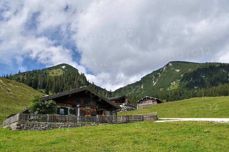 The rustic alpine huts on the Hochalm, with Reifelberg on the left and Sonntagshorn on the right, the highest mountain in the Chiemgau Alps, Salzburger Land, Austria, Europe
