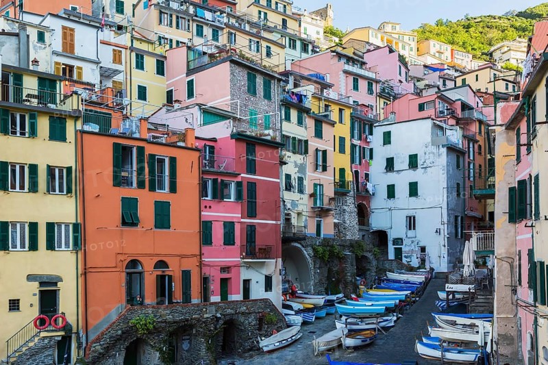 Colourful residential buildings and fishing boats parked in opened space between buildings in Riomaggiore, Cinque Terre, La Spezia, Italy, Europe