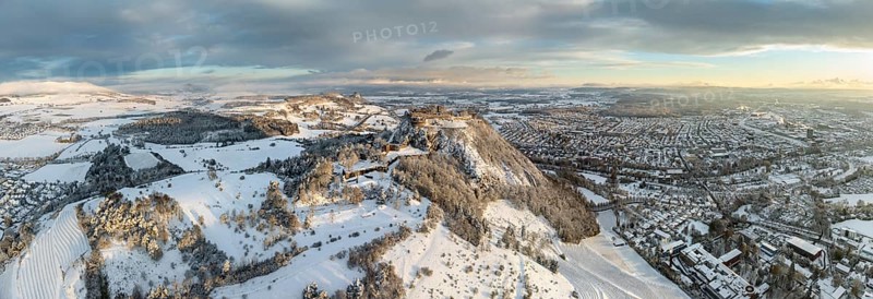 Aerial view, panorama of the snow-covered Hegau volcano Hohentwiel with Germany's largest castle ruins on a cold winter morning, at sunrise, on the right the town of Singen, on the horizon the neighbouring Hegau volcano Hohenkrähen, district of Constance, Baden-Württemberg, Germany, Europe