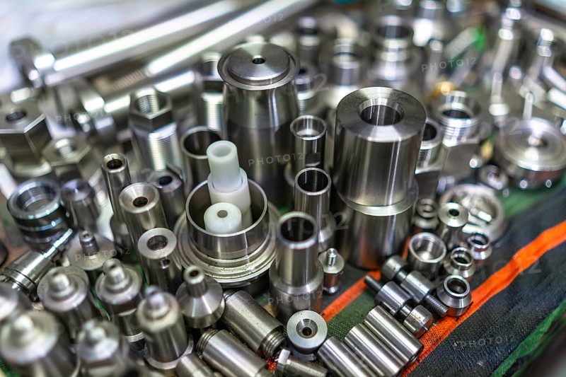 Close- up of a raw of small finished metal pieces placed on surface in metallurgic factory