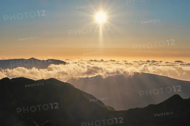 Aerial drone view of mountains over clouds near Pico Ruivo on sunset. Madeira island, Portugal, Europe