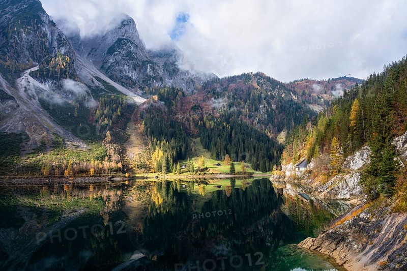 The Vordere Gosausee in autumn. The Gosaukamm on the left. Clouds and sun. Reflection. Vorderer Gosausee, Gosau, Gosau valley, Salzkammergut, Upper Austria, Austria, Europe
