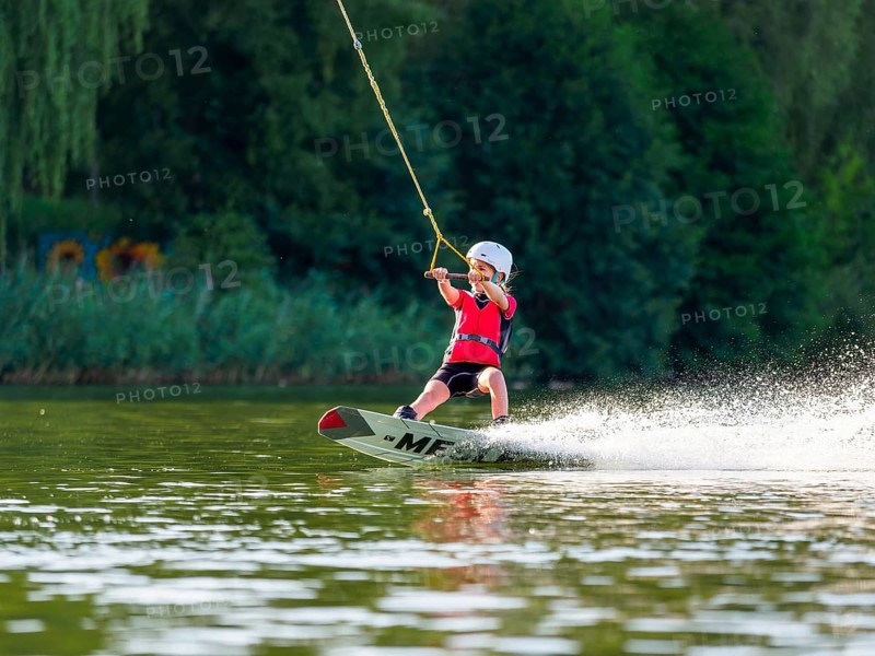Boy or girl with wakeboard in the lake, water sports, water skiing in the wake park