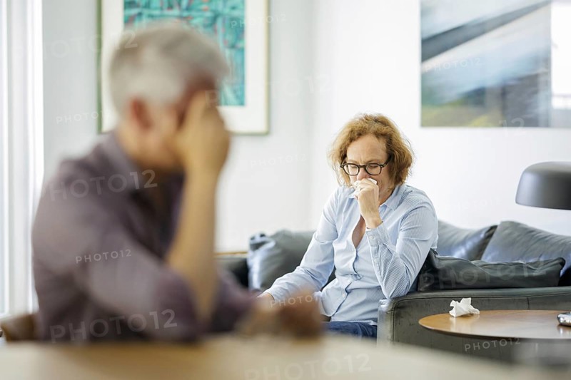 Symbolic photo on the subject of problems in a partnership. An older woman and an older man sitting at home. Berlin, 13.08.2024