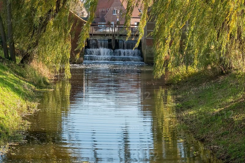 Idyllic river with the weir of a watermill, lined with autumn willow trees, Nienborg, Münsterland, North Rhine-Westphalia, Germany, Europe