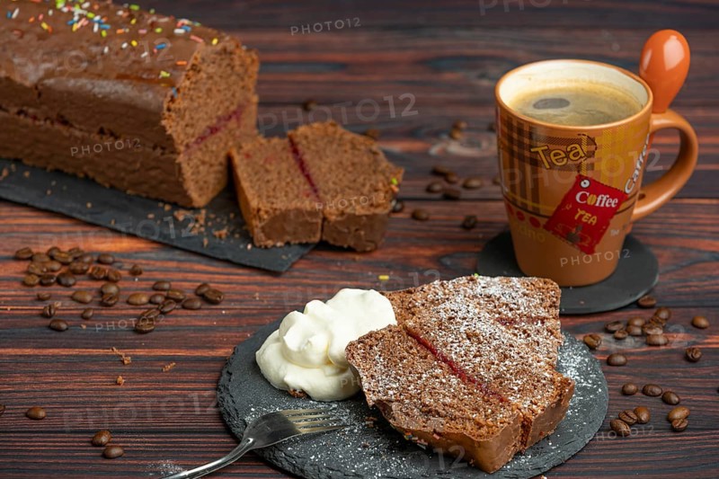 Pieces of chocolate cake with icing sugar, whipped cream and coffee beans lying around