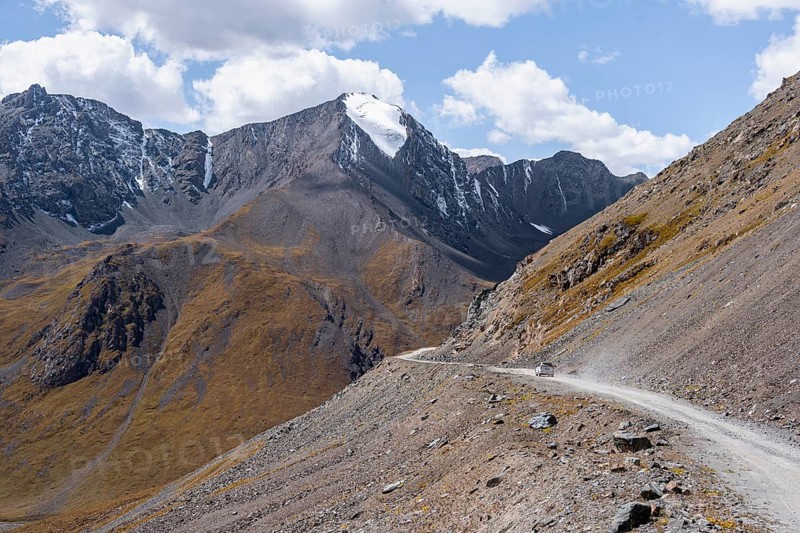 Narrow gravel track in mountain landscape at Chong Ashuu Pass, Tian Shan Mountains, Issyk-Kul, Kyrgyzstan, Asia