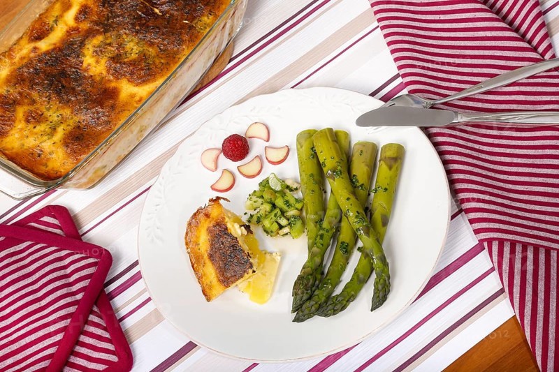 South German cuisine, green asparagus with rhubarb vinaigrette and potato gratin, healthy, vegetables, served on a plate, vegetarian, cutlery, knife, fork, casserole dish with gratin, gratinated, traditional cuisine reinterpreted, food photography, studio, Germany, Europe