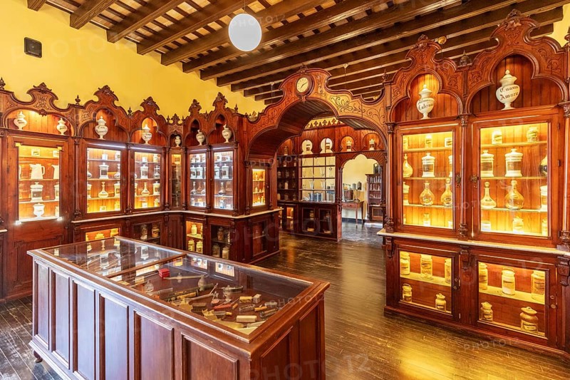 Traditional pharmacy interior with illuminated glass cabinets and woodwork, Jerez