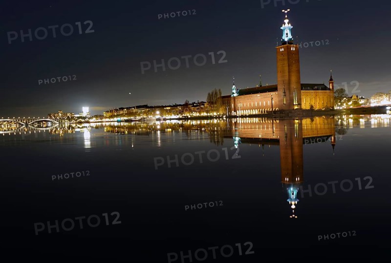 Illuminated building by a calm body of water at night with reflecting water and dark sky, capital city, city hall, Stadshus, Nobel Prize, Stockholm, Sweden, Europe