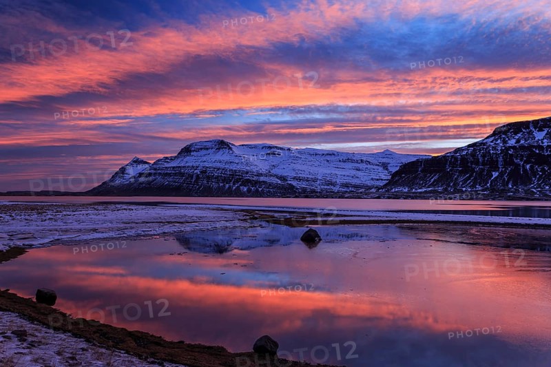 Sunset over a snowy mountain, reflected in a fjord, East Fjords, Iceland, Europe