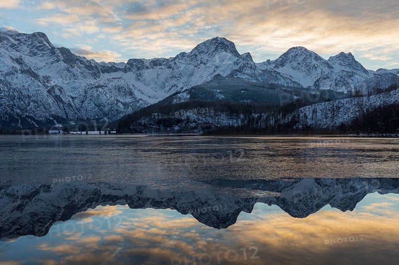 Lake Almsee in winter. Snow on the mountains and some clouds in the sky