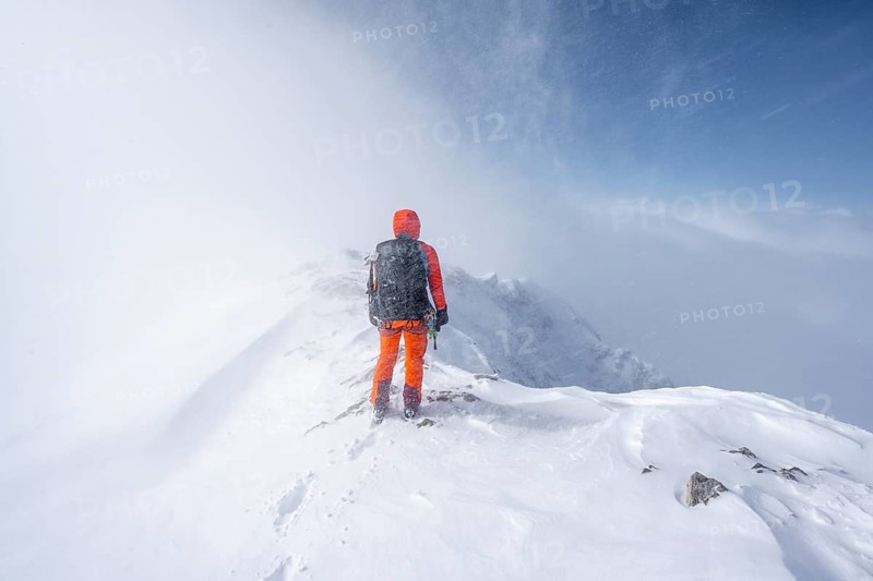 Ski tourer in snowy mountain landscape, at the summit of the Wildhorn, cloudy mood, high tour, Bernese Alps, Bernese Oberland, Switzerland, Europe