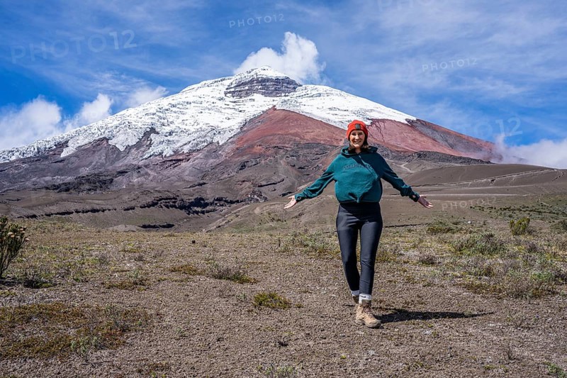 Women poses in front of the Cotopaxi volcano, Cotopaxi, Cotopaxi National Park, Latacunga, Ecuador, South America