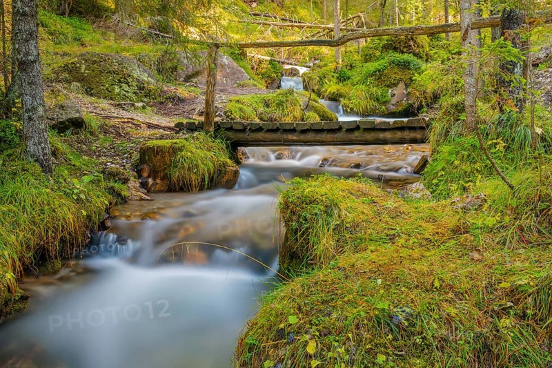 View of a wooden bridge leading over a torrent, long exposure, Dolomites, Puez-Geisler nature park Park, St. Magdalena, Funes, Villnößtal, South Tyrol, Italy, Europe