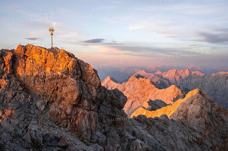 Summit of the Zugspitze with golden summit cross, alpenglow at sunset, Northern Limestone Alps, Wetterstein Mountains, Bavaria, Germany, Europe
