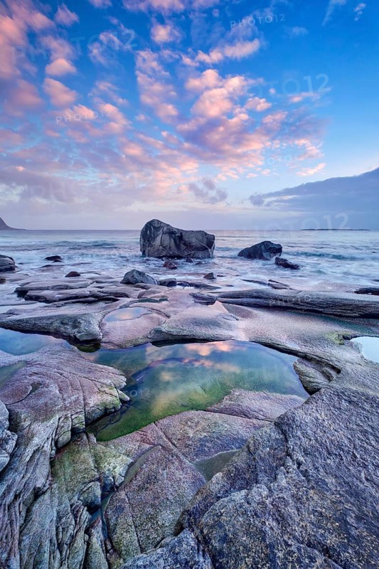 Rocks on beach of fjord of Norwegian sea in winteron sunset. Utakliev beach, Lofoten islands, Norway, Europe
