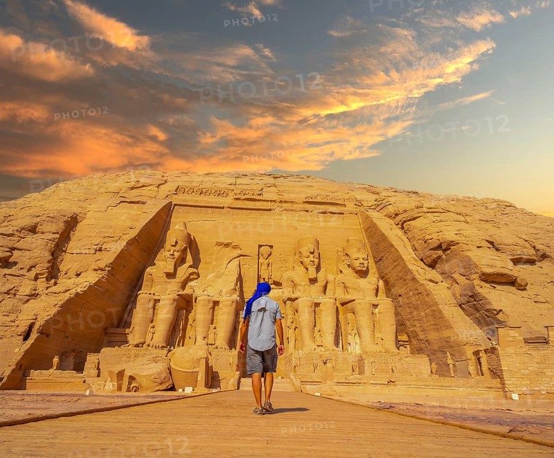 A young man walking towards the Abu Simbel Temple in southern Egypt in Nubia next to Lake Nasser. Temple of Pharaoh Ramses II, travel lifestyle