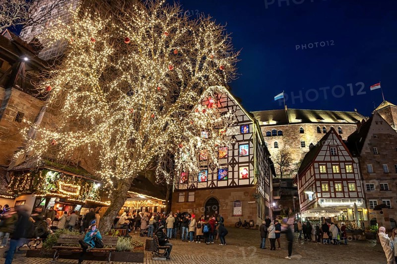 Tiergärtnertorplatz with the Pilatushaus, built in 1489, a historic town house with an Advent calendar on 18 December 2024 at dusk, behind the Kaiserburg, Nuremberg, Middle Franconia, Bavaria, Germany, Europe