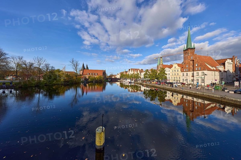 River Trave, quay wall, historic buildings, church towers of St. Marien and St. Petri, reflections on the water surface, blue sky with cumulus clouds, street An der Obertrave, Hanseatic City of Lübeck, Schleswig-Holstein, Germany, Europe