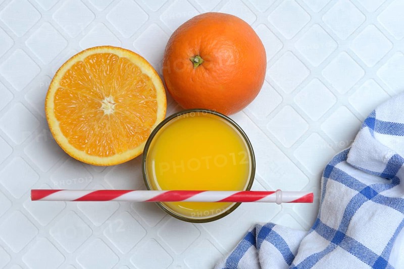 Orange juice in glass and orange, straw