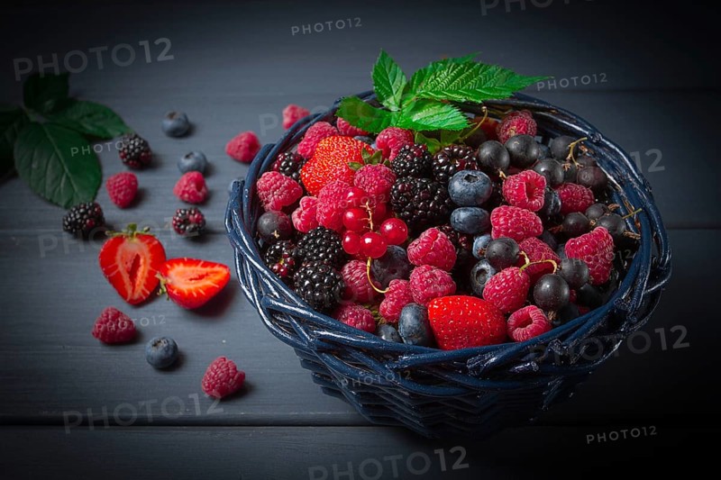 Mix of fresh berries, in a basket, on a wooden gray table, no people, top view