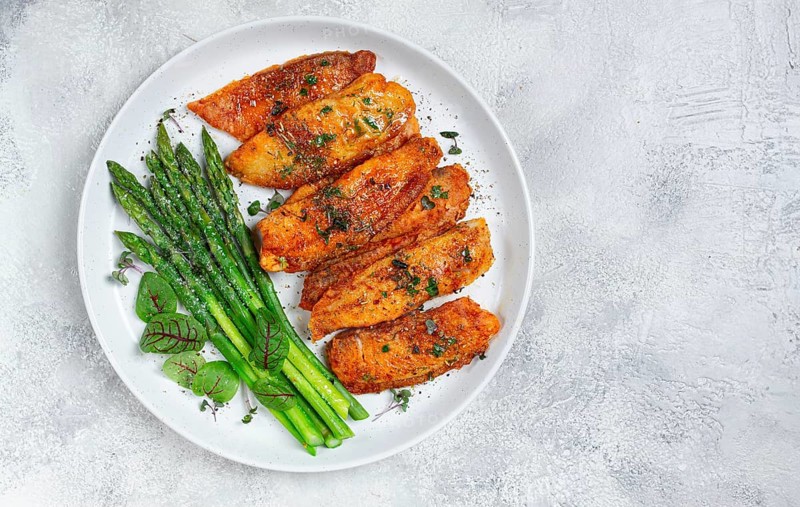 Fried fish fillet, tilapia with asparagus, homemade, no people