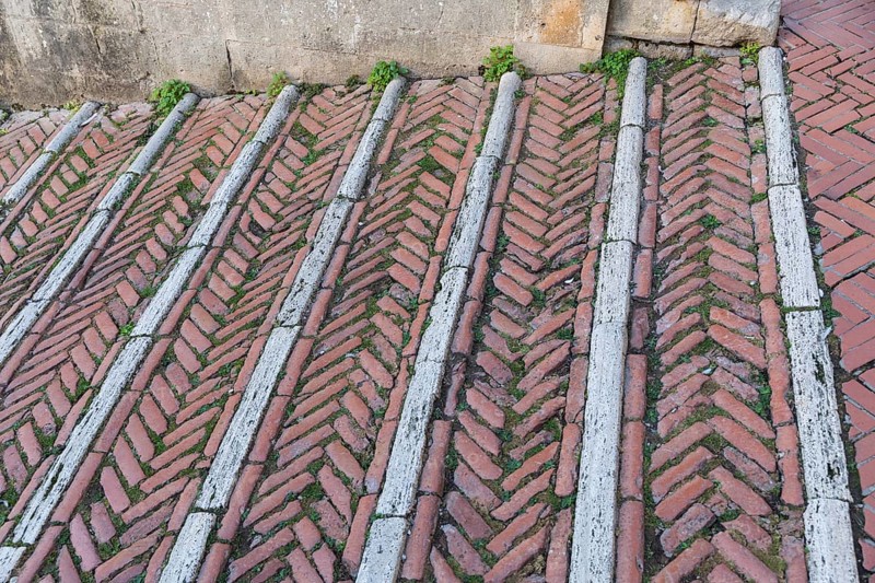 Brick-paved slope in the cathedral square in the medieval town of San Gimignano, province of Siena, Tuscany, Italy, Europe