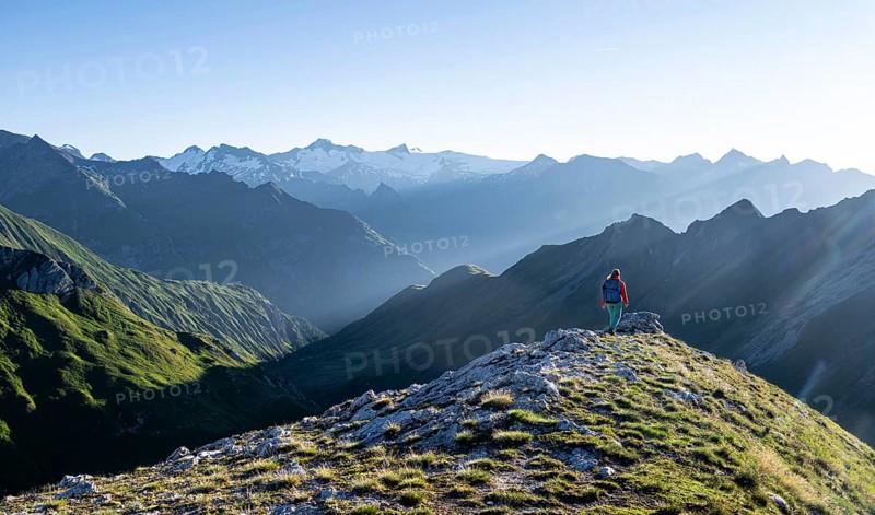 Hiker enjoying the mountain panorama in the morning, Venediger group, behind Dreiherrenkopf, Simonysitze and Großer Geiger, Hohen Tauern, Austria, Europe