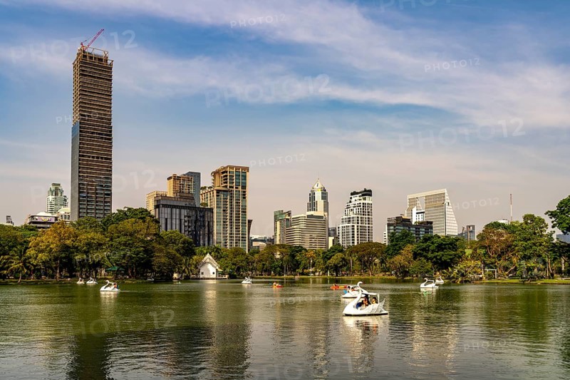 Swan pedal boat on Lumphini Lake in Lumphini Park and the skyline of Bangkok, Thailand, Asia