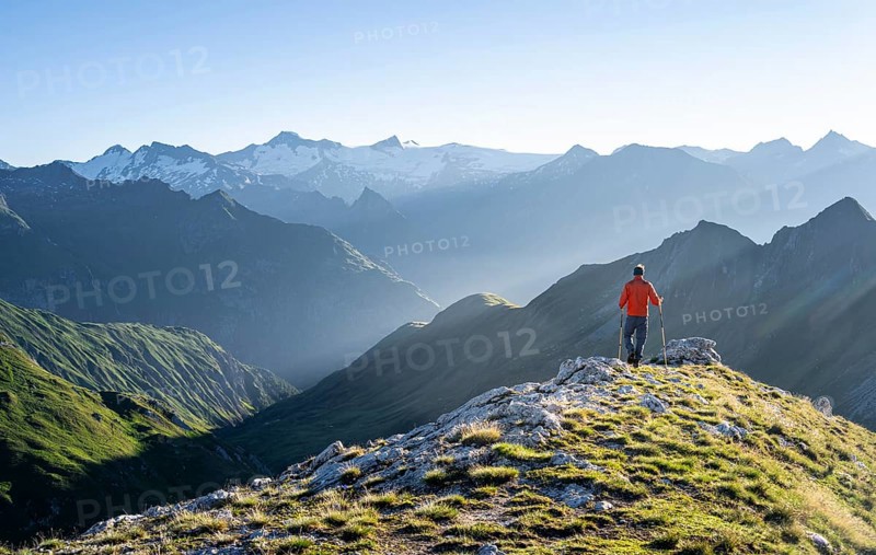 Hiker enjoying the mountain panorama in the morning, Venediger group, behind Dreiherrenkopf, Simonysitze and Großer Geiger, Hohen Tauern, Austria, Europe