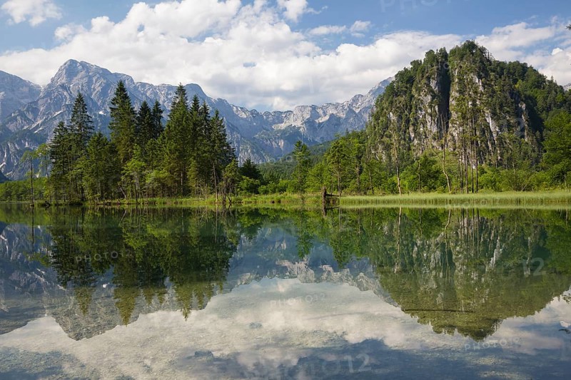 Lake Almsee in summer with totally smooth surface showing reflexion of the mountain Ameisstein