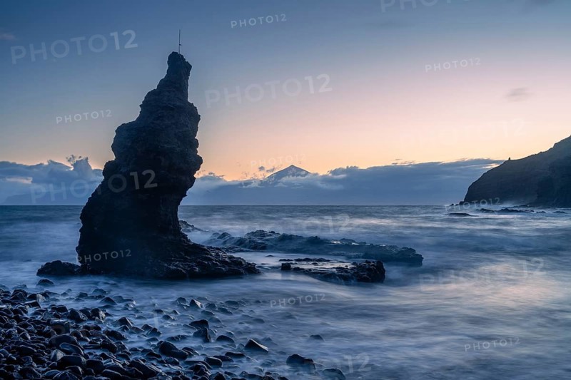 Before sunrise on the beach at Playa de La Caleta. Rocks and sea. Tenerife and the Teide in the background. Long exposure. La Gomera, Canary Islands, Spain, Europe